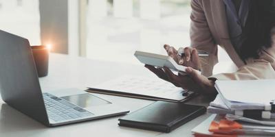 Close up Businessman using calculator and laptop for calaulating finance, tax, accounting, statistics and analytic research concept photo