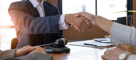 Businessman shaking hands to seal a deal with his partner lawyers or attorneys discussing a contract agreement. photo