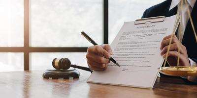 Male lawyer working with contract papers and wooden gavel on tabel in courtroom. justice and law ,attorney, court judge, concept. photo