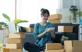 Business woman start up small business entrepreneur SME success .freelance woman working at home with Online Parcel delivery. SME and packaging deliveryconcept photo