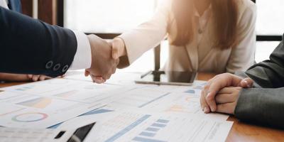 Two confident business man shaking hands during a meeting in the office, success, dealing, greeting and partner concept. photo