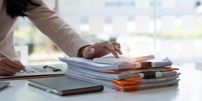 Close up Businessman using calculator and laptop for calaulating finance, tax, accounting, statistics and analytic research concept photo