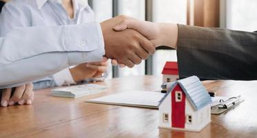 Successful agreement , estate,home buying contract concept, buyer shaking hand with bank empoyees after finishing signing contract in office photo