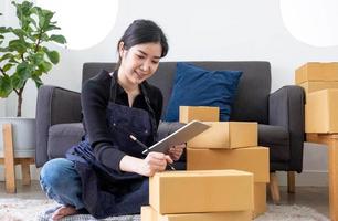 Retrato de mujer joven asiática SM trabajando con una caja en casa el lugar de trabajo.Propietario de una pequeña empresa de inicio, pequeña empresa emprendedora o empresa independiente en línea y concepto de entrega. foto