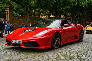 GERMANY, FULDA - JUL 2019 red FERRARI F430 Type F131 cabrio is a sports car produced by the Italian automobile manufacturer Ferrari from 2004 to 2009 as a successor to the Ferrari 360. The car is an u photo