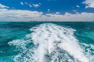 Trail of water left by a boat in the lake, travel image on a boat in Caribbean Ocean near Cancun, Yucatan, Mexico photo