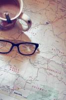 Map, map of Washington state, pen, glasses, cell phone, coffee cup on the table. photo