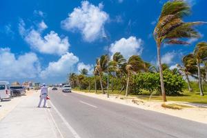 SUV driving on the road with palms on a sunny day near Cancun, Mexico photo