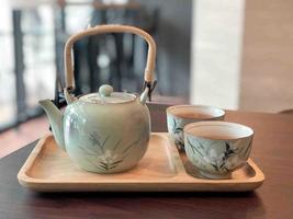 Tea pot and tea cup on table photo