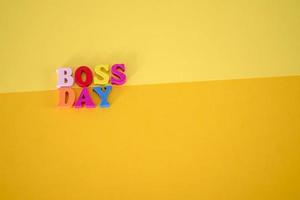 National Happy Boss Day. Multicolored letters on a yellow blank piece of paper. photo