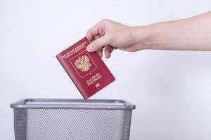 pasaporte de la federación rusa en un bote de basura. el hombre tira el pasaporte a la basura. foto