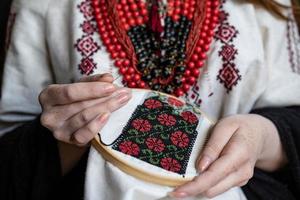 A girl embroiders a traditional Ukrainian vyshyvanka pattern photo