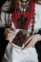 A girl embroiders a traditional Ukrainian vyshyvanka pattern photo