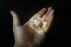 la bola de cristal del planeta tierra y la imagen de la mano. foto