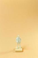 white  figure miniature on orange pastel for business content. photo