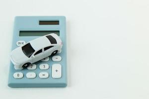 juguete de coche blanco y fondo blanco calculadora azul. foto