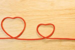 Red rope heart on wood plate valentine content. photo