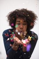 African American woman blowing confetti in the air photo