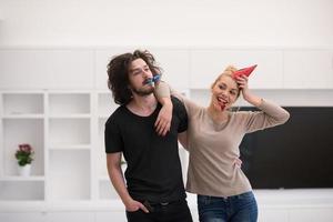 pareja en sombreros de fiesta soplando en silbato foto