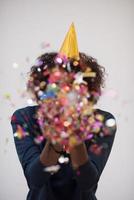 African American woman blowing confetti in the air photo