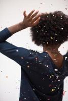 mujer afroamericana soplando confeti en el aire foto