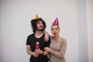 couple in party hats blowing in whistle photo