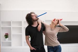 couple in party hats blowing in whistle photo