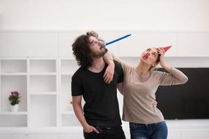 couple in party hats blowing in whistle photo