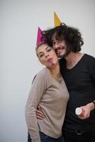 couple in party hats blowing in whistle photo