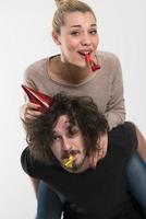 couple in party hats blowing in whistle photo