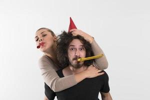 pareja en sombreros de fiesta soplando en silbato foto