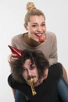 couple in party hats blowing in whistle photo