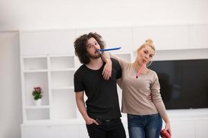 couple in party hats blowing in whistle photo