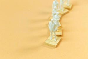 white  figure miniature on orange pastel for business content. photo