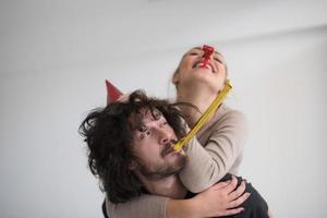 couple in party hats blowing in whistle photo