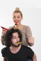 couple in party hats blowing in whistle photo