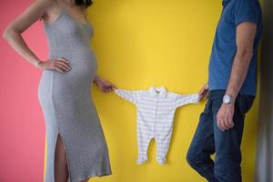 young couple holding baby bodysuits photo