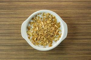 Morning food almond flakes  and milk in white bowl on wood table. photo