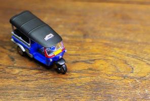 tuk tuk taxi  toy  on wood table close up image. photo