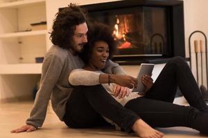 pareja multiétnica usando una tableta en el piso foto