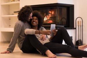 multiethnic couple using tablet computer on the floor photo