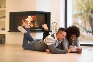 multiethnic couple using tablet computer on the floor photo