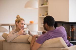 Young multiethnic couple  in front of fireplace photo