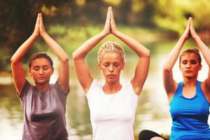 women meditating and doing yoga exercise photo