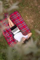 top view of man using a laptop computer under the tree photo