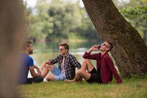 men sitting on the bank of the river photo