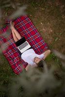 top view of man using a laptop computer under the tree photo