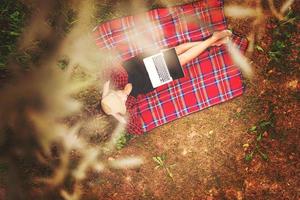 top view of man using a laptop computer under the tree photo