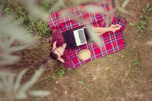 top view of man using a laptop computer under the tree photo