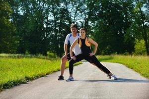 Couple doing stretching exercise  after jogging photo